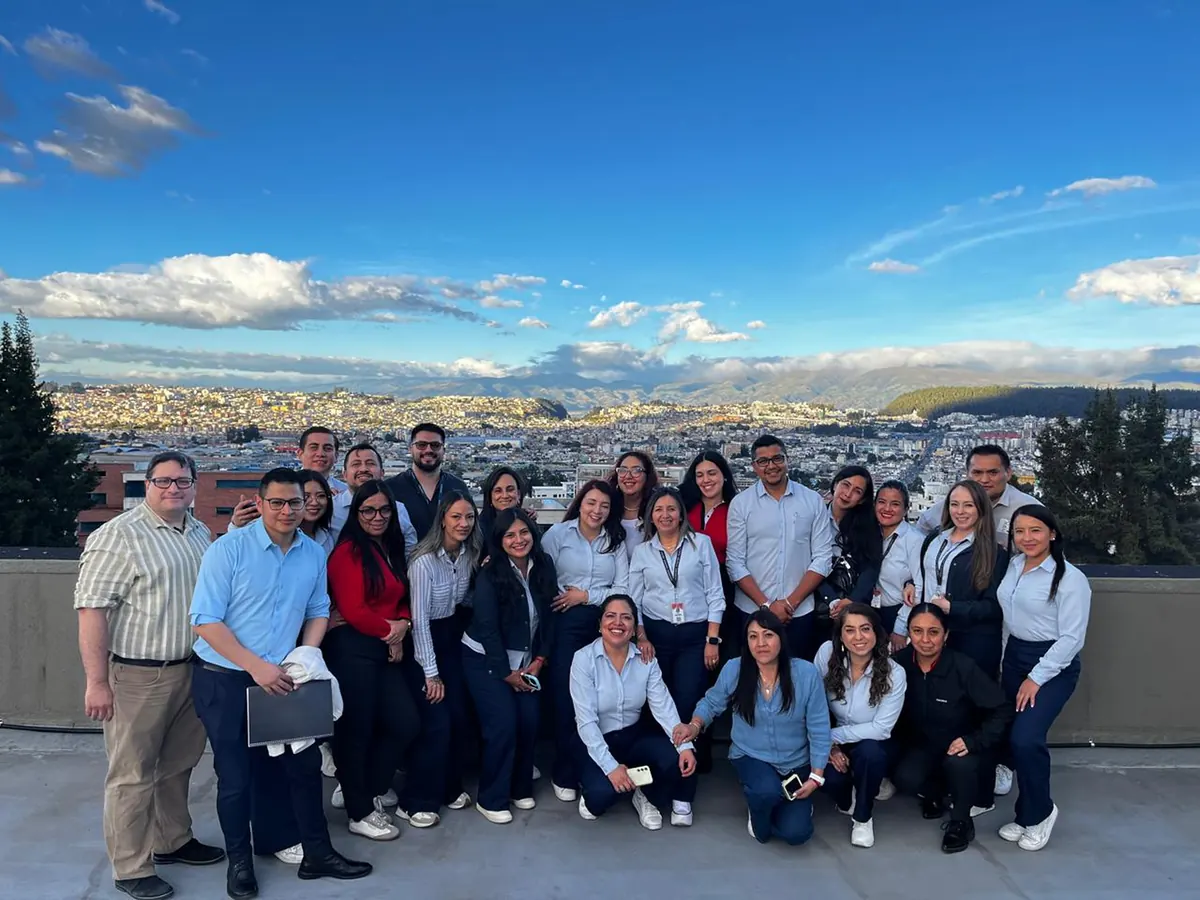 Grupo completo del taller en una terraza de Quito, con la ciudad de fondo.